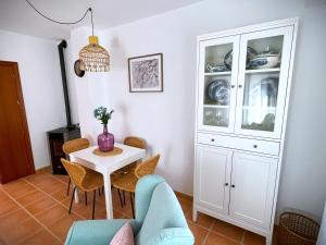 a dining room with a white cabinet and a table at El Balcón de Fuenteheridos in Fuenteheridos