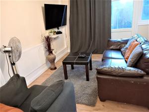 a living room with a couch and a table at London Deluxe Four Bedroom House in Dagenham