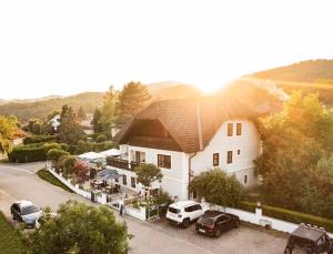 Aggsbach DorfRestaurant Domingo Gonzalez的一座大型白色房子,前面有汽车停放