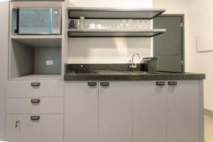 a kitchen with white cabinets and a sink at Moderno e Central - CA905 in Maringá
