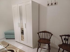 a room with a white cabinet and two chairs at Ca' Moschini in Mesola