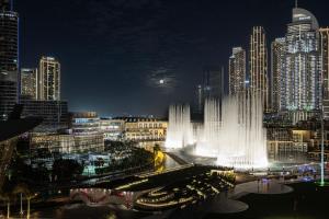 a view of a city at night with a fountain at Best View In Dubai With FULL Burj Khalifa, Fountains, Park View, Next to Dubai Mall and Opera in Dubai