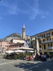 a group of people sitting at tables in front of a building at Lake Front Apartments, Lecco in Lecco +31 photos
