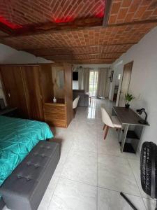 a bedroom with a bed and a desk and a table at Mini Casita, around nature in Santa Cruz de la Soledad +22 photos
