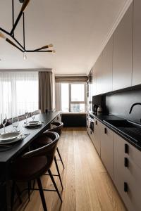 a kitchen with white cabinets and black counter tops at Klingerka Apartment, 25th floor with Free parking and view of Castle and Danube in Bratislava