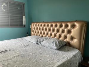 a bed with a leather headboard in a bedroom at Apart. centro Ribeirão Hospital São Lucas in Ribeirão Preto