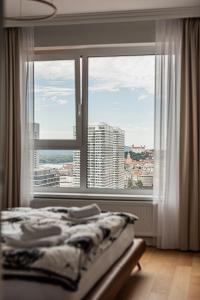 a bedroom with a bed and a large window at Klingerka Apartment, 25th floor with Free parking and view of Castle and Danube in Bratislava