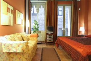 um quarto de hotel com uma cama, um sofá e uma televisão em Friendly Rentals Dali em Barcelona