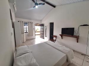 a bedroom with a bed and a flat screen tv at Pousada Estalage in Cabo Frio