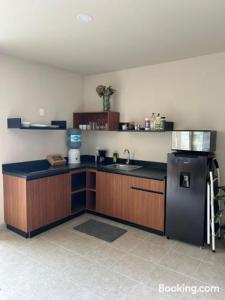 カンクンにあるNew Centric 1BR apartment with gym & poolの黒い冷蔵庫とシンクのあるキッチン