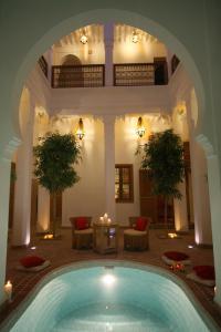 una piscina en medio de un patio con un edificio en Riad Chameau FDC Hôtel SPA, en Marrakech