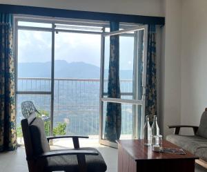 a living room with a large window with a view at Blissful Stay, 2-min drive from MG Market in Gangtok