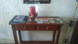 a table with a red candle and books on it at Green Fountain Villa 5 in Port Alfred