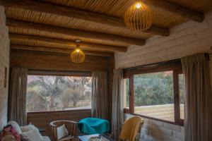 a room with two windows and a table and chairs at Casa Sinforosa in Purmamarca