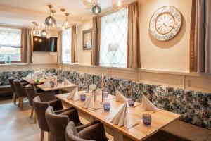 a restaurant with wooden tables and chairs and a clock on the wall at Restaurant Domingo Gonzalez in Aggsbach Dorf