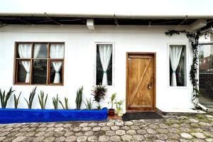 Casa blanca con puerta y ventanas de madera en Sweet Home, en Puerto Ayora