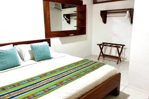 Un dormitorio con una cama con un espejo y una silla. en Sweet Home, en Puerto Ayora