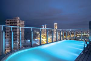 una piscina en la azotea de un edificio con vistas al perfil urbano en Puerto Norte Design Hotel en Rosario