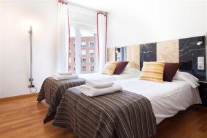 2 letti in camera d'albergo con asciugamani di Stay U-nique Apartments Salvador Espriu a Barcellona