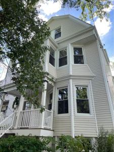 a large white house with a large balcony on it at A Great Day in Newark - Elite 3 BR Sunny Retreat in Newark