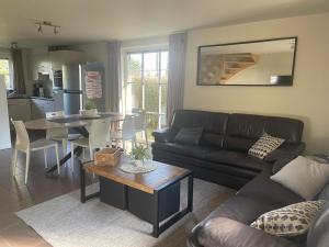 un salon avec un canapé et une table dans l'établissement Vakantiehuisje aan zee vlakbij Plopsaland en het strand - Casa Memphis, à La Panne
