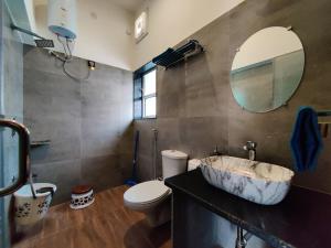 a bathroom with a sink and a toilet and a mirror at Chitrangan The Homestay of Udaipur in Udaipur