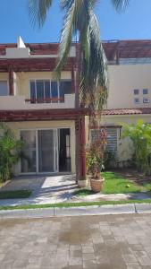 une maison avec un palmier devant dans l'établissement Residencial Terrasol, à Acapulco