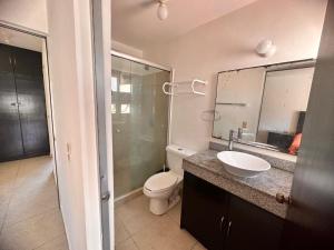 une salle de bain avec toilettes, lavabo et miroir dans l'établissement Residencial Terrasol, à Acapulco 7 autres photos