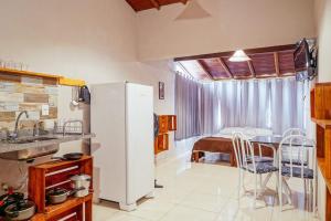 a kitchen with a refrigerator and a table with chairs at Flats Paz in Itacaré