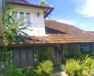 a white house with a red roof at The Beach House Marari in Mararikulam