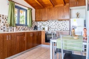 a kitchen with wooden cabinets and a table at Nenes House in Koroni