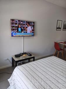 a bedroom with a bed and a tv on the wall at Loft Dorrego Rio in Rosario