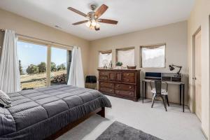 a bedroom with a bed and a desk and a ceiling fan at Cathedral Spires Luxury Home Tucked in the MTN'S in Colorado Springs