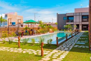 a swimming pool with a table and an umbrella at Patacho Porto Gamboa in Pôrto de Pedras