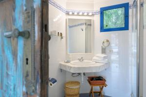 une salle de bain blanche avec un lavabo et un miroir dans l'établissement Estudio Tegoyo, à Mácher