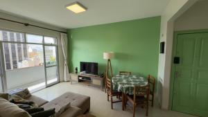 een woonkamer met een bank en een tafel bij Curitiba Central - Apartamento completo e perto de tudo in Curitiba