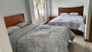 a bedroom with two beds and a window at Amazing Home - Habitación Triple in Baños +7 photos