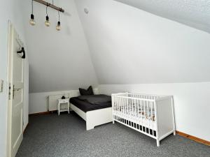 a bedroom with a crib in a room at Ferienwohnung Friesenstube in Zetel