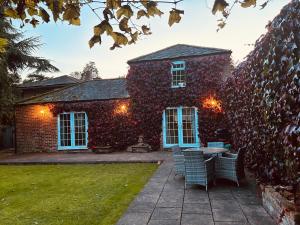 a brick house with a table and chairs in the yard at The Old Coach House at Stewton in Louth
