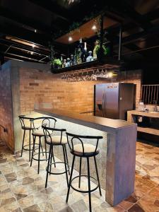 a bar with four bar stools in a restaurant at Finca la Milagrosa in Popayan