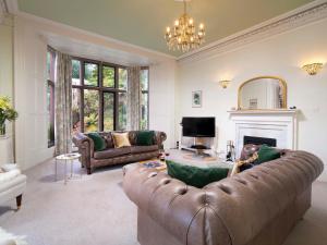 Una sala de estar con un sofá y una chimenea. en Brunt How, en Ambleside