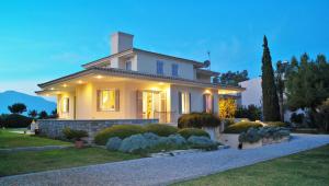 a white house with a landscaping at DH Epavlis in Rio