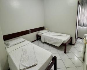 a small room with two beds in it at Pousada Central in Feira de Santana