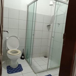 a bathroom with a toilet and a glass shower at Casa temporada in Baía Formosa