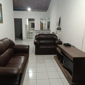 a living room with two leather couches and a table at Casa temporada in Baía Formosa