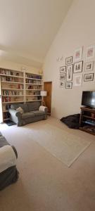 a living room with a couch and a television at The Dairy at Wyke Farm in Axminster