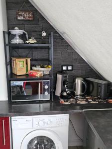 eine Küche mit Mikrowelle und Waschmaschine in der Unterkunft Gîte Vallée de Munster 3 étoiles chez Flavie & Ludo in Muhlbach-sur-Munster + 15 Fotos
