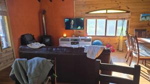 a living room with a couch and a microwave at Cabaña MISUEÑO in Punta Del Diablo