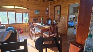 a dining room with a table and chairs in a cabin at Cabaña MISUEÑO in Punta Del Diablo