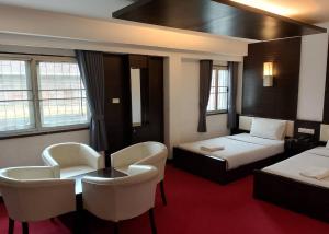 a hotel room with a bed and a table and chairs at Phu Luang Hotel in Ban Tha Phae